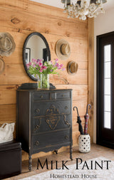 Black antique dresser painted in Homestead House Coal Black Milk Paint, styled with tulips, hats, and umbrellas.