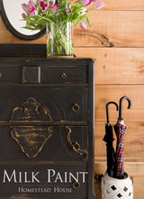 Black dresser painted with Coal Black Milk Paint by Homestead House, topped with tulips and umbrellas.