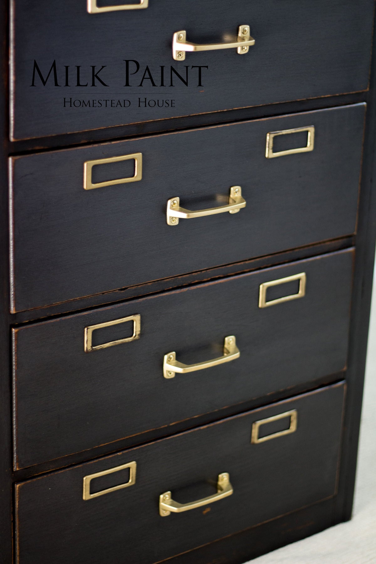 Four-drawer dark wood filing cabinet with brass handles, finished in Homestead House Coal Black Milk Paint.