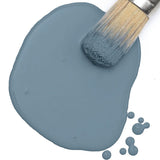 Brush on Fusion Mineral Paint Coastal Blue Milk Paint, with droplets visible on a white surface.