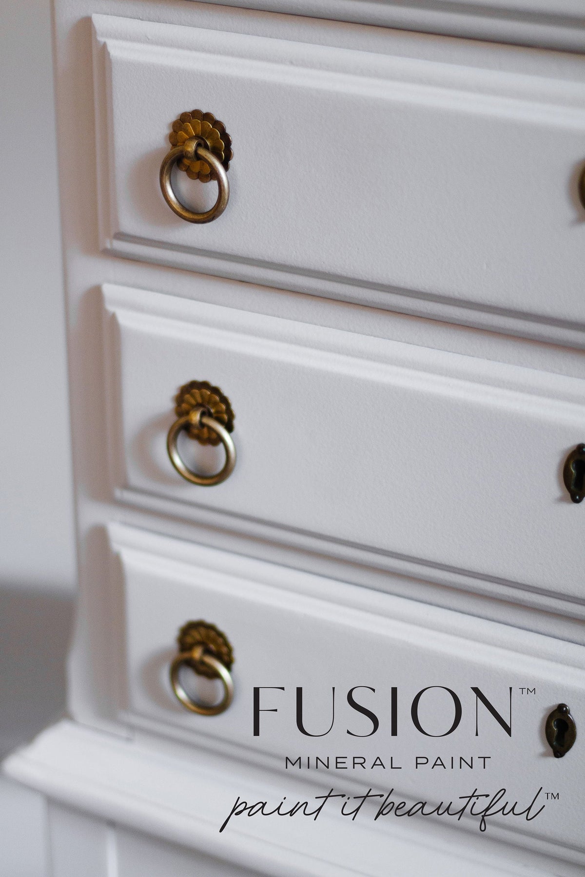 Dresser drawers with brass handles, painted in Fusion Mineral Paint’s Cobblestone; logo at lower right corner.