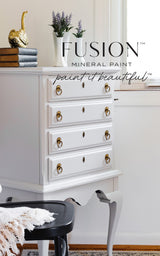 Dresser in Cobblestone Fusion Mineral Paint with gold handles, topped with books and décor.