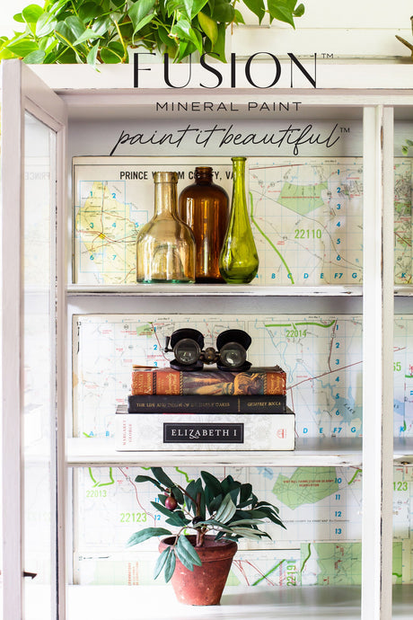Cobblestone Fusion Mineral Paint shelf displaying glass bottles, vintage binoculars, books, map, and plant.