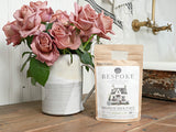 Ceramic pitcher with pink roses beside a bag of Old Fashioned Milk Paint Cobblestone by Sweet Pickins.