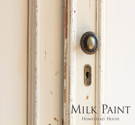 Distressed cream door with knob, keyhole, and “Combed Wool Milk Paint by Homestead House” label.