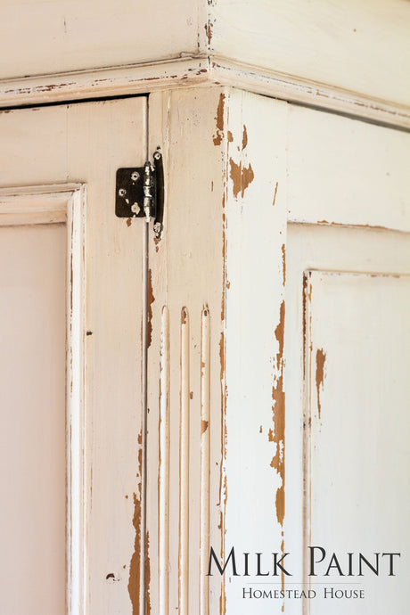 Chipped cabinet corner with exposed wood; “Combed Wool Milk Paint by Homestead House” text visible.