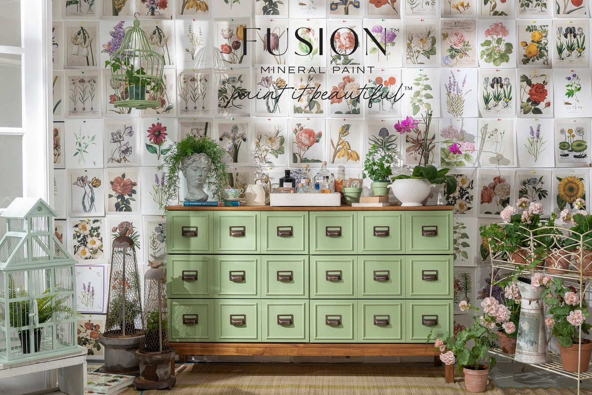 Green cabinet with drawers by Fusion Mineral Paint in Conservatory green, shown with potted plants and garden decor.