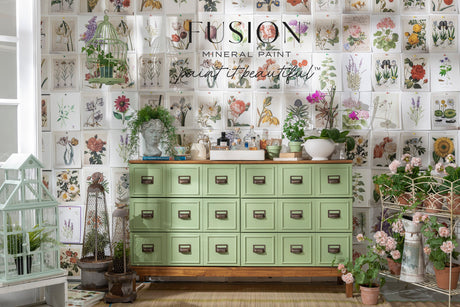 Green cabinet with drawers by Fusion Mineral Paint in Conservatory green, shown with potted plants and garden decor.