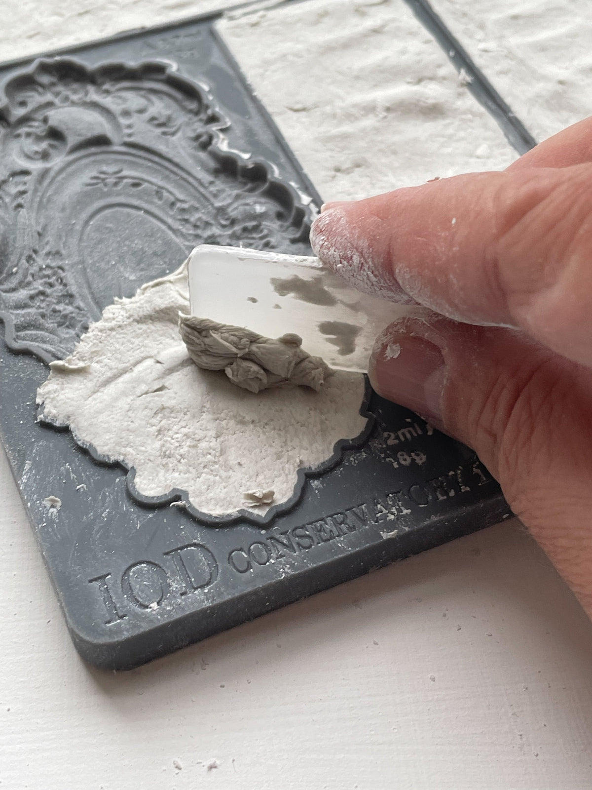 Hand pressing clay into an IOD Conservatory Labels Mould.