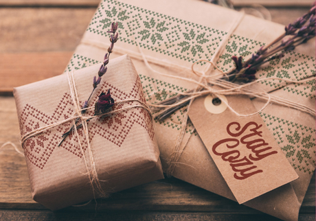 Two brown paper gifts with dried flowers and “Stay Cozy” tags stamped using I.O.D. Cozy Stamp (2022 Limited Release).