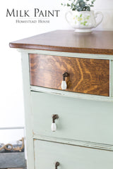 Wood dresser painted light green (Homestead House Craftsman Milk Paint) with a teapot of fresh greenery on top.