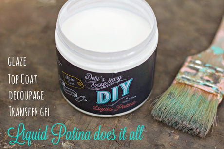 Open Crystal Clear Chandelier Liquid Patina by DIY Paint Co. next to a used paintbrush on a rustic surface.