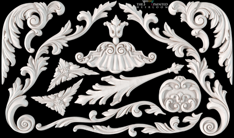 I.O.D. Dainty Flourishes Mould white wood appliques with floral designs on black background.