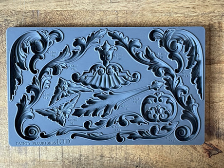 Dainty Flourishes Mould by IOD, Iron Orchid Designs, with ornate shapes and volume markings on wood block.