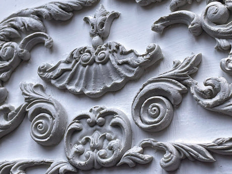 Ornate white plaster wall with swirling patterns created using Dainty Flourishes Mould by I.O.D.