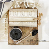 Wood sample, black liquid, and brush on board for Old Fashioned Milk Paint Dark Beeswax Furniture Polish.