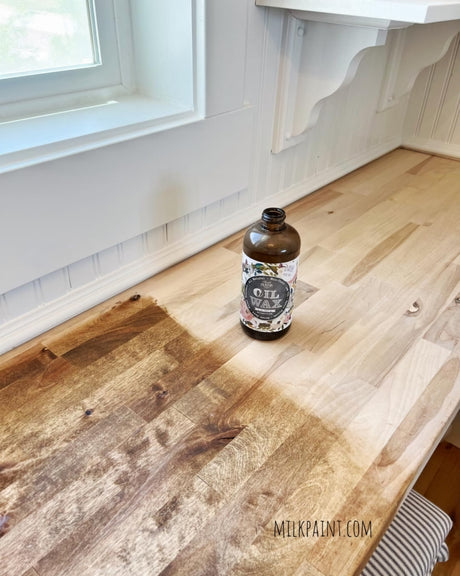 Sweet Pickins Dark Oil Wax bottle with wood sample showing difference between treated and untreated finish.