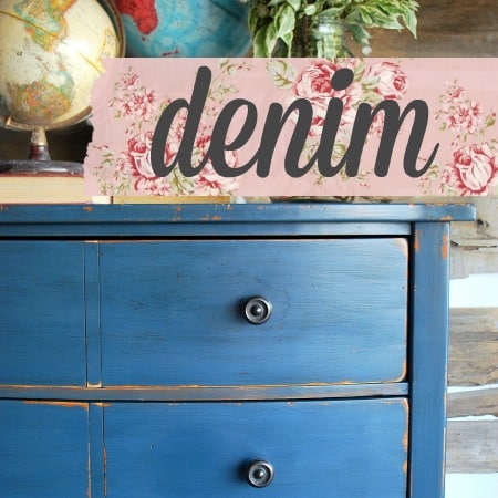 Blue dresser in Old Fashioned Milk Paint Denim with black knobs, topped with a globe and “denim” floral sign.