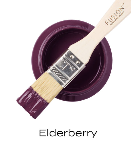 Paintbrush with purple Fusion Mineral Paint Elderberry on bristles resting atop open can labeled Fusion Mineral Paint.