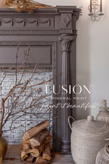 Dark gray ornate fireplace with stacked firewood, wicker basket, and Elmwood Fusion Mineral Paint finish.