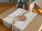 Brown gift box with white lace, twine, and I.O.D. Emblems Mini-Stamp tag.