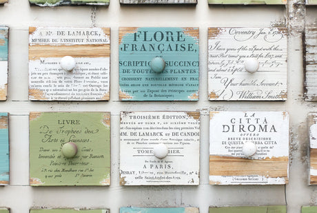 Nine wooden drawers with knobs, labeled in I.O.D. Ephemeral Type Stamp script by Iron Orchid Designs.