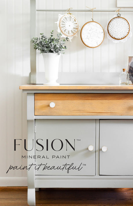 Gray and wood hutch painted with Fusion Mineral Paint Eucalyptus, featuring white knobs and crochet hoops on a rail above.