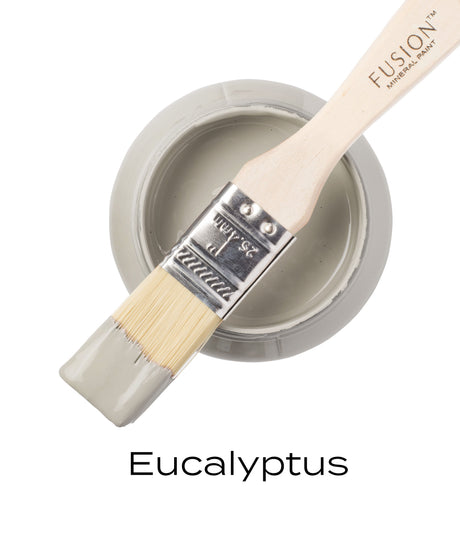 Open jar of Fusion Mineral Paint Eucalyptus, muted green shade, with brush dipped and resting on the rim.