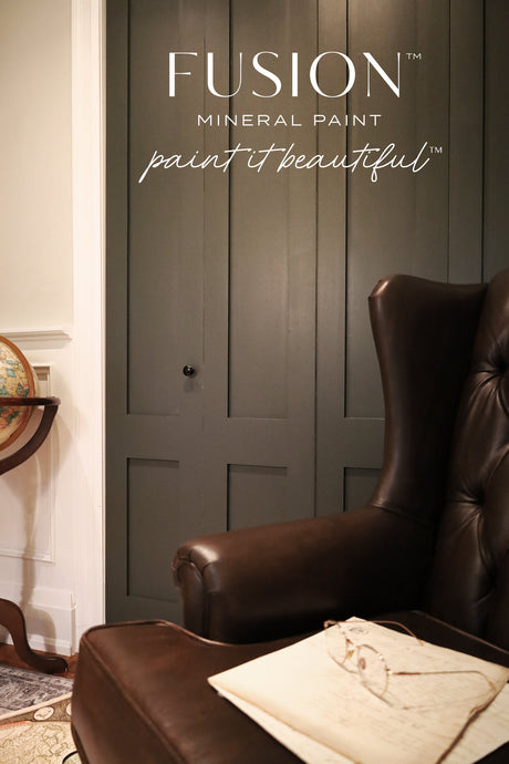 Leather chair and small table with globe beside paneled door painted in Everett Fusion Mineral Paint.