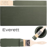 Paintbrush with olive green Everett by Fusion Mineral Paint, alongside swatch and open can of the same paint.