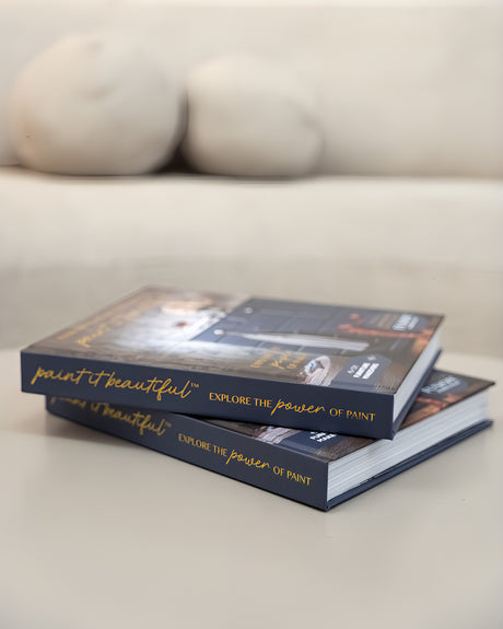 Two stacked “Everything You Need to Know to Paint in Beautiful” books by Fusion Mineral Paint on a white surface.