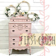 Pink vintage dresser painted with Old Fashioned Milk Paint, decorated with florals, embroidery hoops, and floral banner.