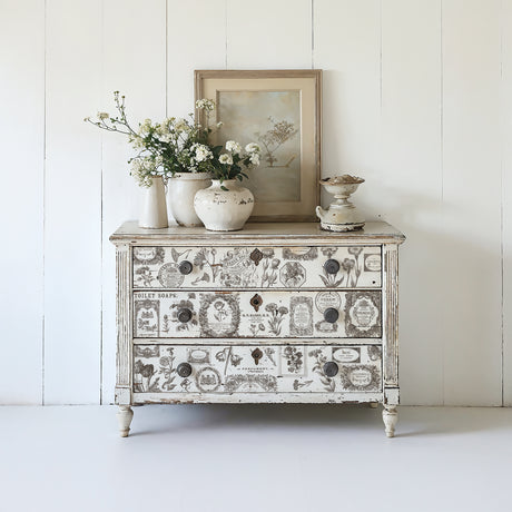 Vintage dresser with IOD Retired Floriography Paint Inlay, topped with white flower vases and art.