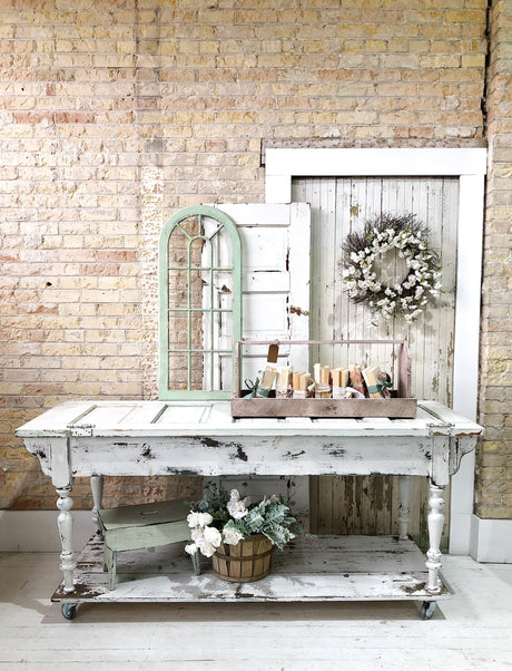 Candles on a rustic table; wreath on door painted with Old Fashioned Milk Paint Flour Sack, vintage decor accents.