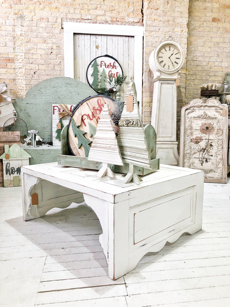 White table painted in Flour Sack by Old Fashioned Milk Paint with decorative trees arranged on top.