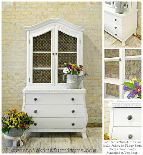 White vintage hutch in Flour Sack by Old Fashioned Milk Paint, chicken wire doors, floral lining, vase on top.