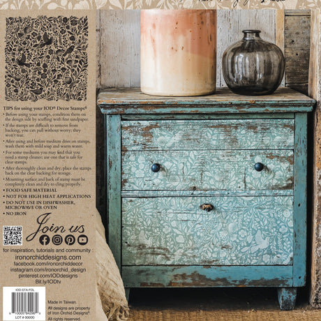 Distressed blue cabinet with large brown vase, small gray bottle, and I.O.D. Folk Story Stamp by Iron Orchid Designs.
