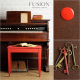 Table in Fort York Red by Fusion Mineral Paint with antique keys on its brown textured top.