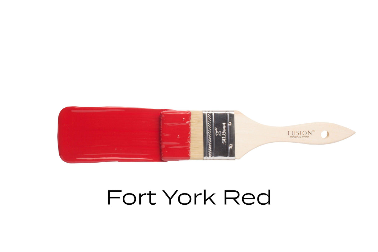 Paintbrush with Fort York Red Fusion Mineral Paint by Fusion Mineral Paint on a plain white background.