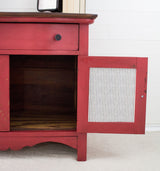 Red cabinet in Homestead House Fort York Red Milk Paint with one drawer and open, empty door.