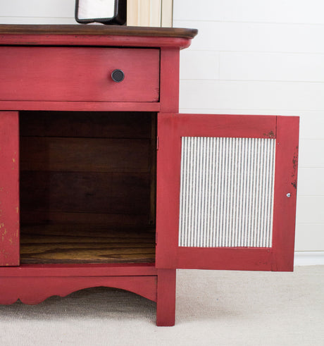 Red cabinet in Homestead House Fort York Red Milk Paint with one drawer and open, empty door.