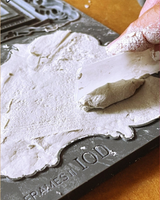 Hand applying white plaster with flat tool to I.O.D. Frames 2 Mould by Iron Orchid Designs.