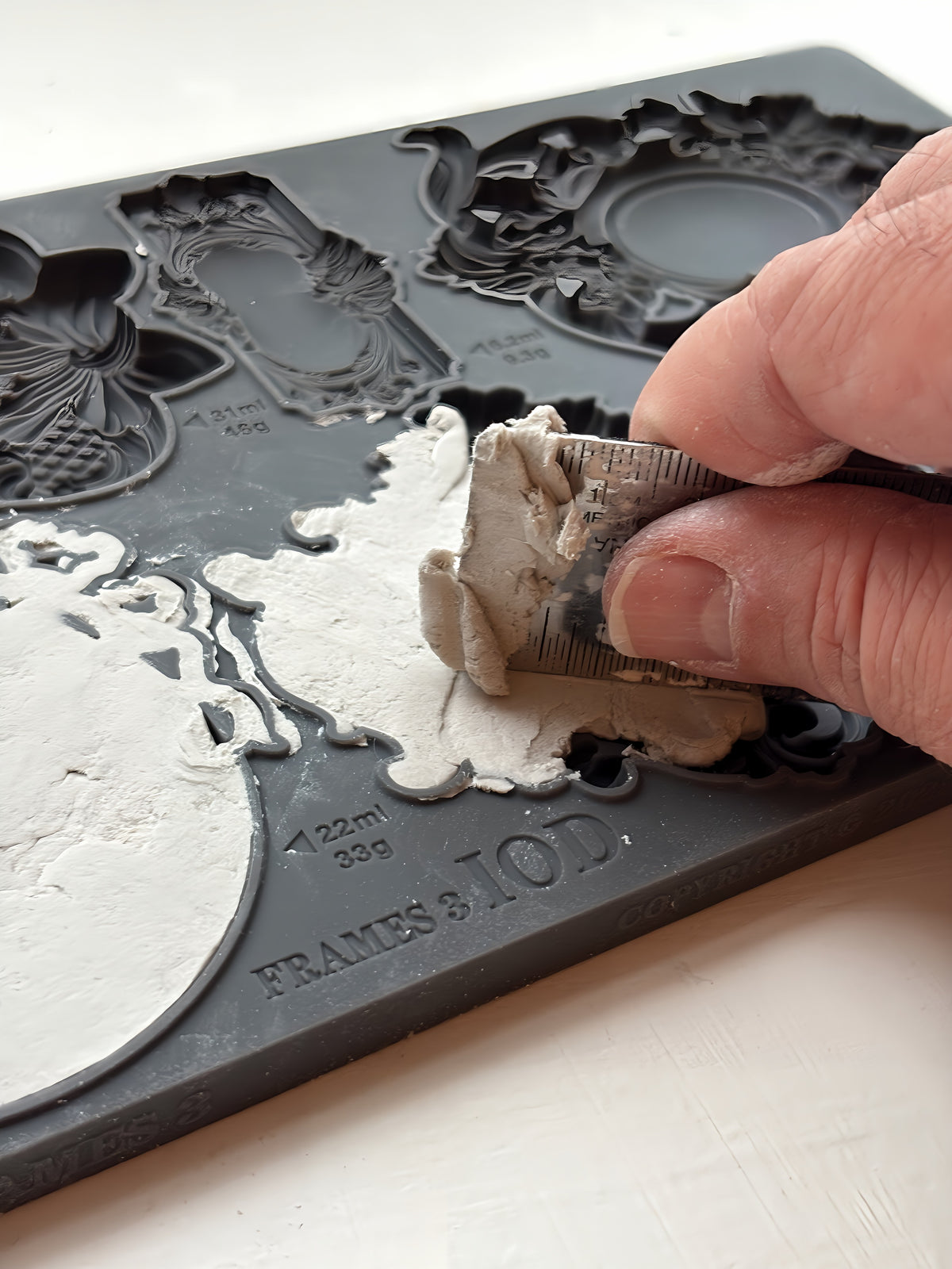 Hand pressing white clay into IOD Frames 3 Mould to create ornate vintage-style mini frames. Brand: I.O.D.