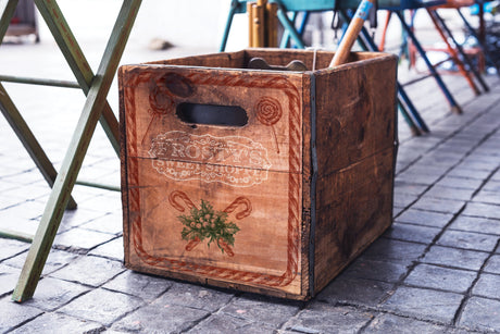 Frosty’s Sweet Shoppe Stamp (2024) by I.O.D. displayed on a crate next to a green metal chair.
