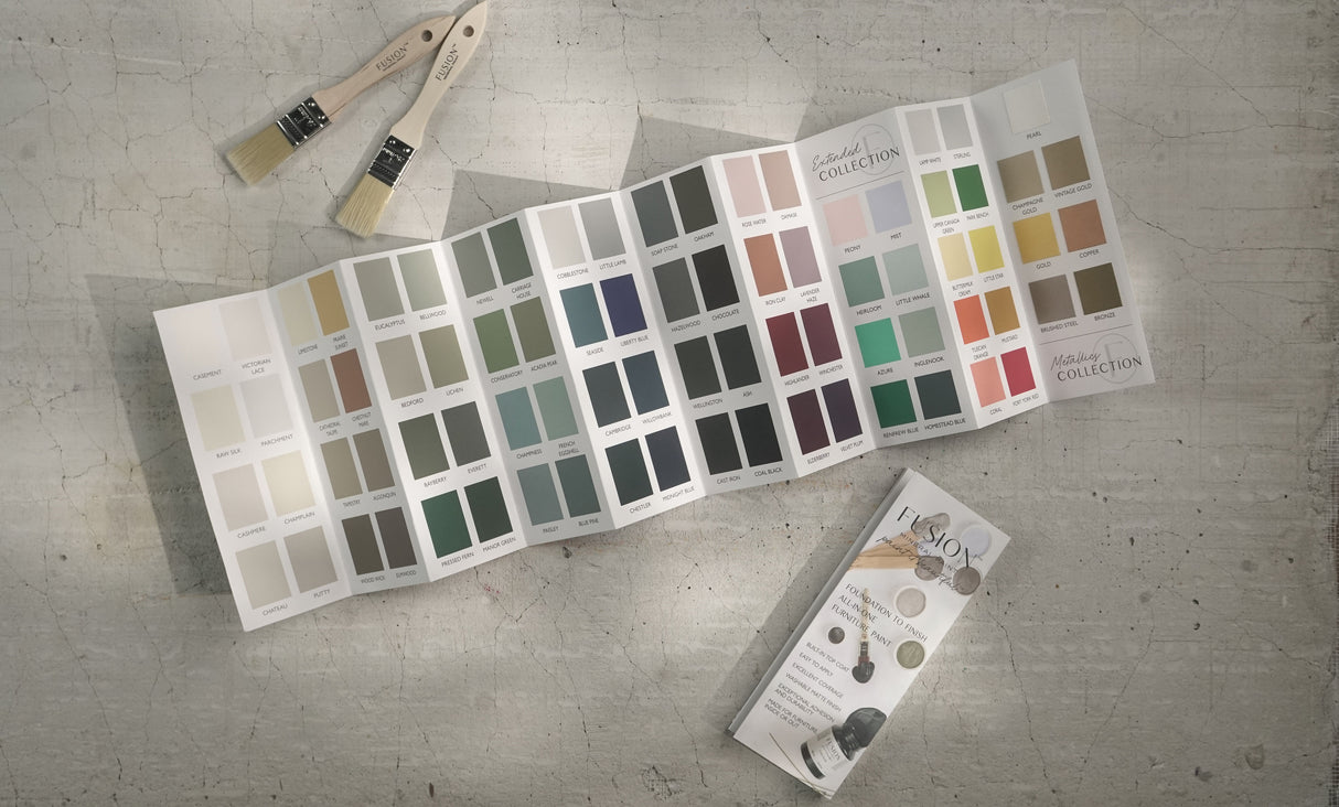 Fusion Mineral Paint True to Color Card 2024, paintbrushes, and brochure on a textured surface.