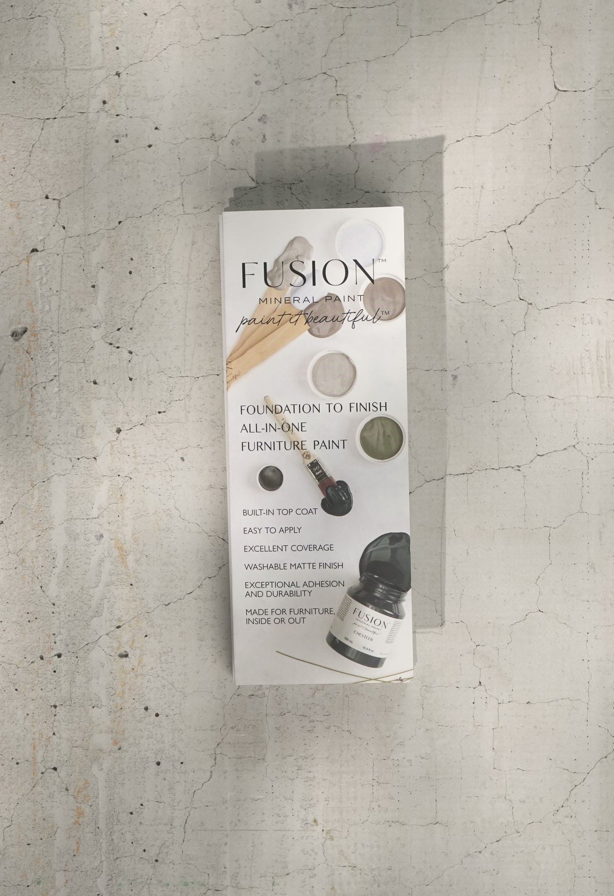 Fusion Mineral Paint box with True to Color Card (2024) and paint chips displayed on cracked concrete.