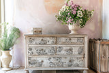 Dresser with DIY décor, I.O.D. Garden Bouquet Stamp details, and two potted plants on either side.