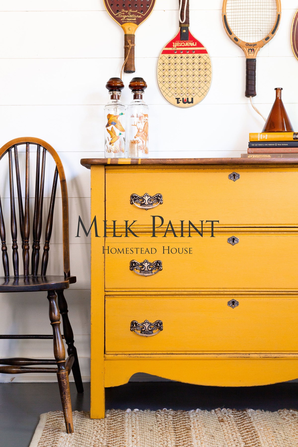 Yellow dresser painted in Homestead House Garden Seed Milk Paint, styled with vintage rackets.