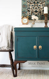 Teal sideboard in Homestead House Gaspe Green Milk Paint with gold handles and vintage decor on a patterned rug.