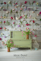 Cabinet in Homestead House Gatineau Milk Paint with pink flowers in vases and a backdrop of hanging blooms.
